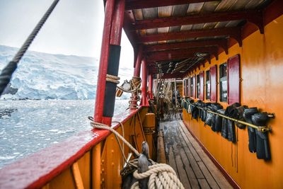 Boat sailing on sea against mountain