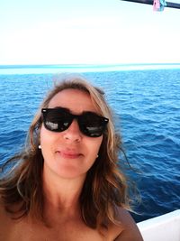 Portrait of young woman in sunglasses at sea