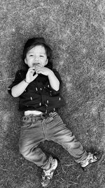 Portrait of cute baby boy lying on land