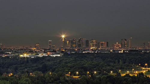 Illuminated cityscape against sky at night