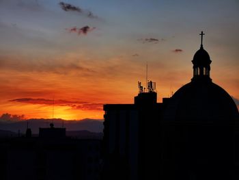 Silhouette buildings against sky during sunset