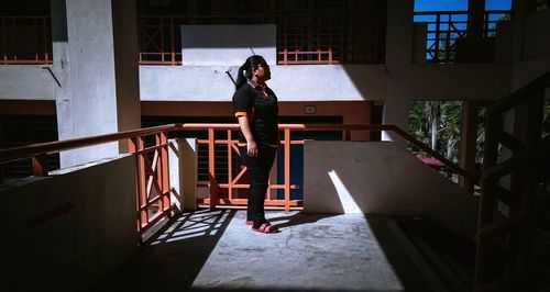 Full length of woman standing on railing