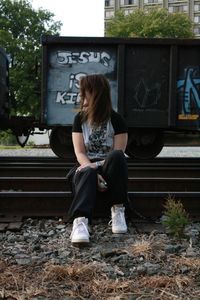 Low section of woman sitting on railroad station