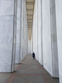 Rear view of person walking in corridor of building