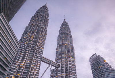 Low angle view of petronas towers against cloudy sky