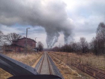 Railroad track against cloudy sky