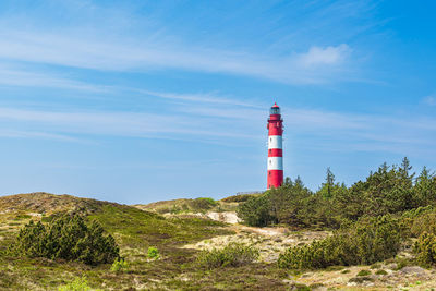 Lighthouse by sea against sky