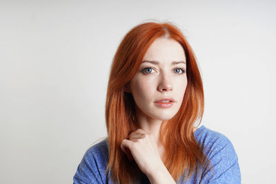 Portrait of young woman against white background