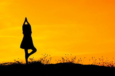 Silhouette girl doing yoga during sunset