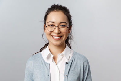 Portrait of a smiling young woman against white background