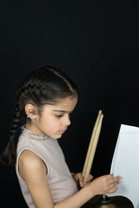 Side view of a girl sitting on book