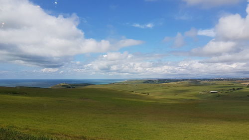 Scenic view of field against cloudy sky