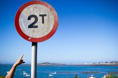 Close-up of road sign against clear blue sky