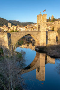 Arch bridge over river against sky