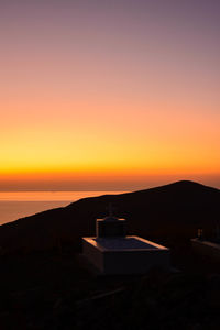 Scenic view of silhouette mountains against orange sky
