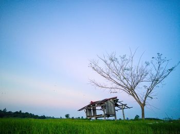 Built structure on field against clear blue sky