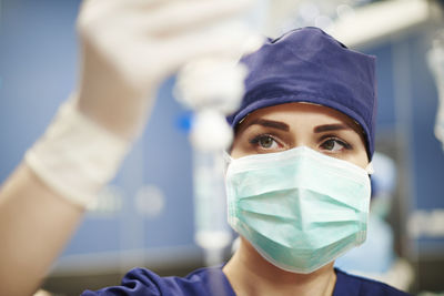 Close-up of doctor holding iv drip while standing in hospital