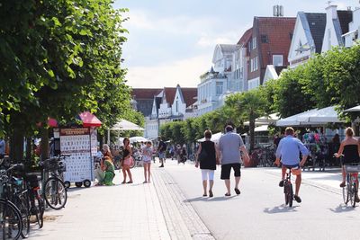 People on street amidst buildings in city