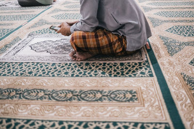 Low section of man sitting on carpet