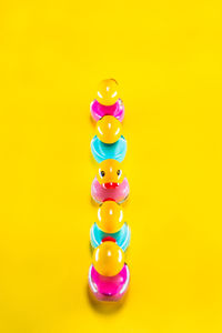 Close-up of multi colored candies against yellow background