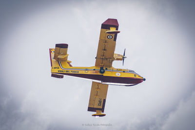 Low angle view of airplane flying against sky