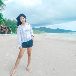 Full length portrait of young woman standing on beach