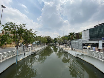 Bridge over canal in city against sky