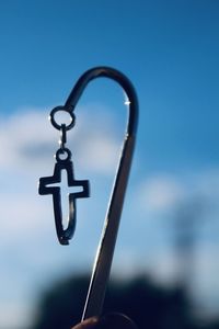 Close-up of silhouette chain against blue sky