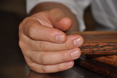 Close-up of hand touching table