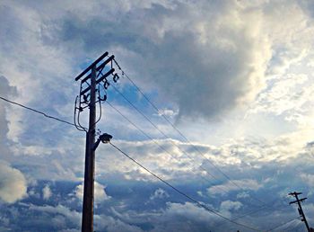 Low angle view of power lines against cloudy sky