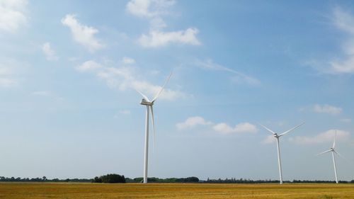 Windmill on field against sky