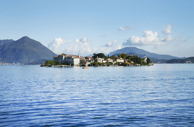 Scenic view of sea by buildings against sky