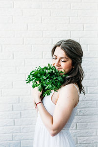 Beautiful woman standing against white wall