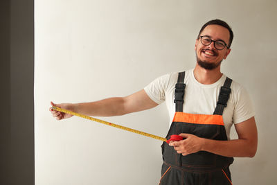 Portrait of young man standing against wall