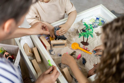 High angle view of mother and daughter drawing on table