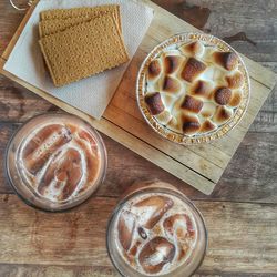 High angle view of smores on cutting board and drink glasses