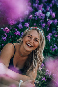 Portrait of a smiling young woman with pink flower