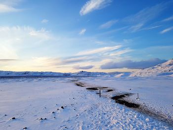 Scenic view of snow covered land against sky