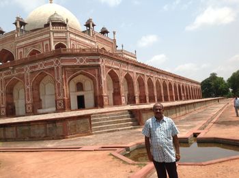 Man standing at humayun tomb against sky
