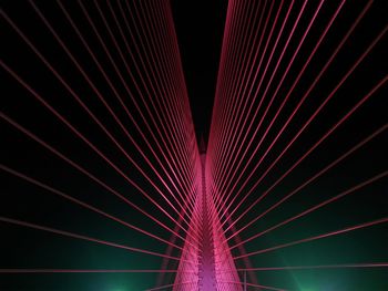 Low angle view of illuminated suspension bridge at night