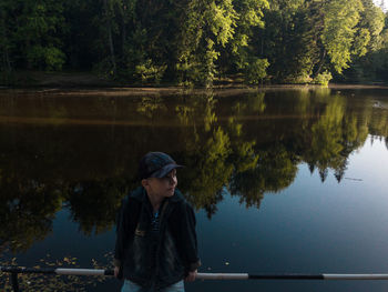   boy seatting  near lake 