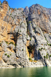 Rock formation in sea against sky