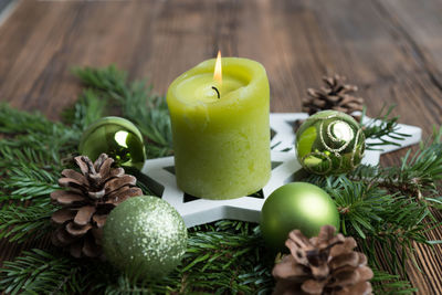 Close-up of lit candle on wreath