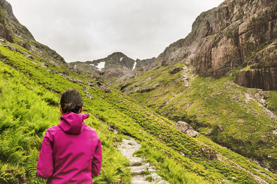 Rear view of woman on mountain against sky