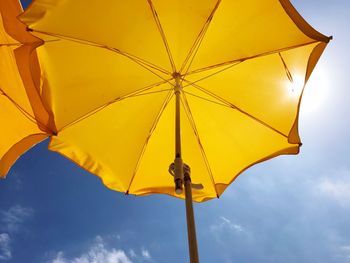 Low angle view of yellow umbrella against sky