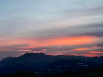 Scenic view of silhouette mountains against sky at sunset