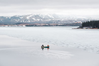 People on snow covered mountain against sky