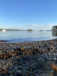 Surface level of stones on beach against clear sky