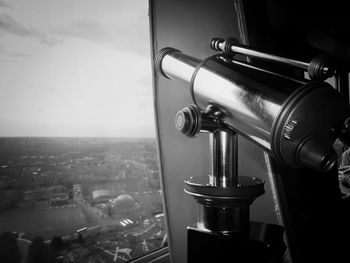 Close-up of coin operated binoculars facing cityscape