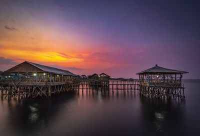Pier over sea against sky during sunset